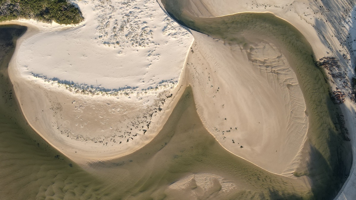 Drone aerial shot capturing unique patterns of sand and water at a coastal area in Victoria, Australia