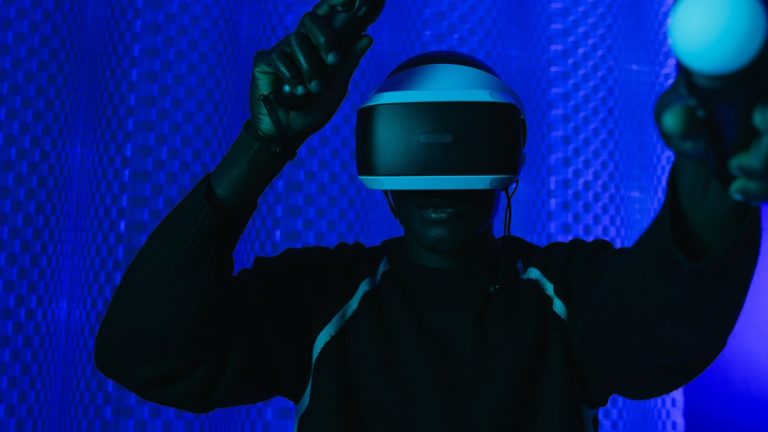 Person enjoying a virtual reality gaming session with a VR headset and controllers