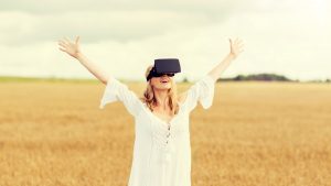 Young woman using a virtual reality headset in a field