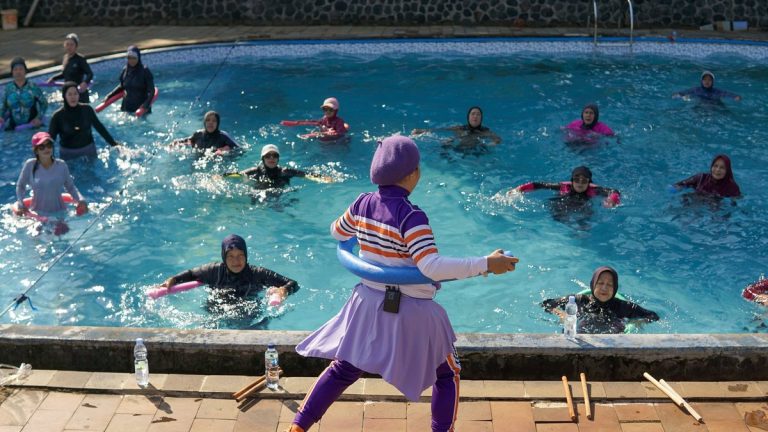 Women participating in a water aerobics class under the sun in West Java, Indonesia