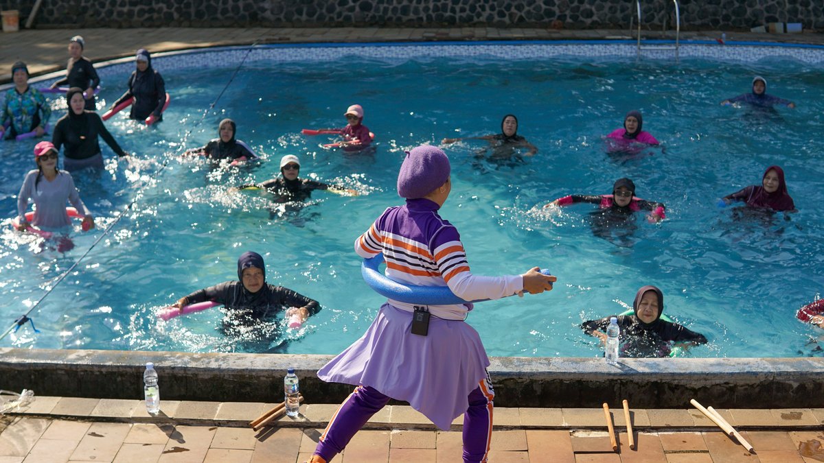 Women participating in a water aerobics class under the sun in West Java, Indonesia