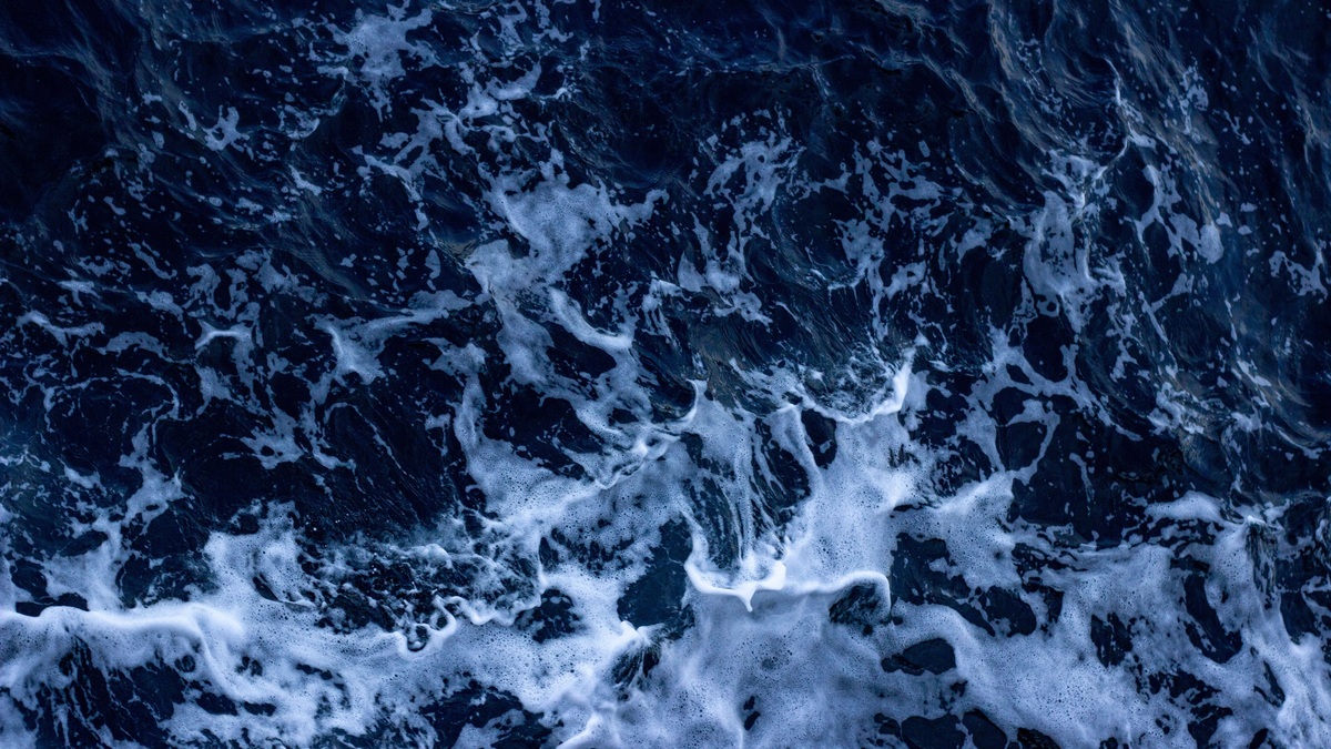 Aerial view of crashing ocean waves captured in Çanakkale, Türkiye, showcasing white foam and dark blue water