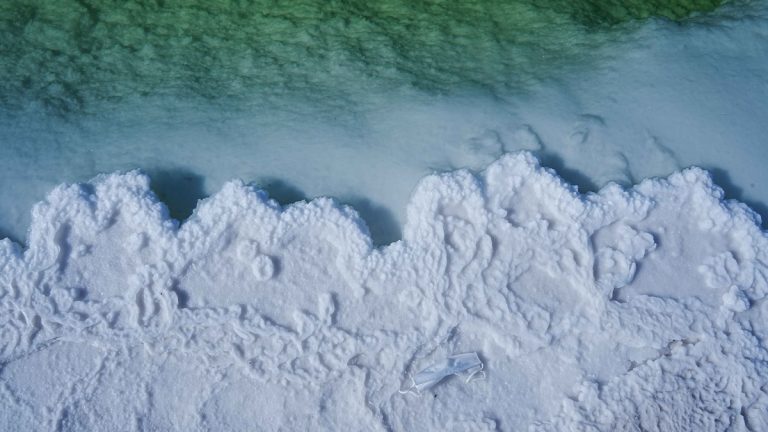 White_salt_deposits_beside_green_water