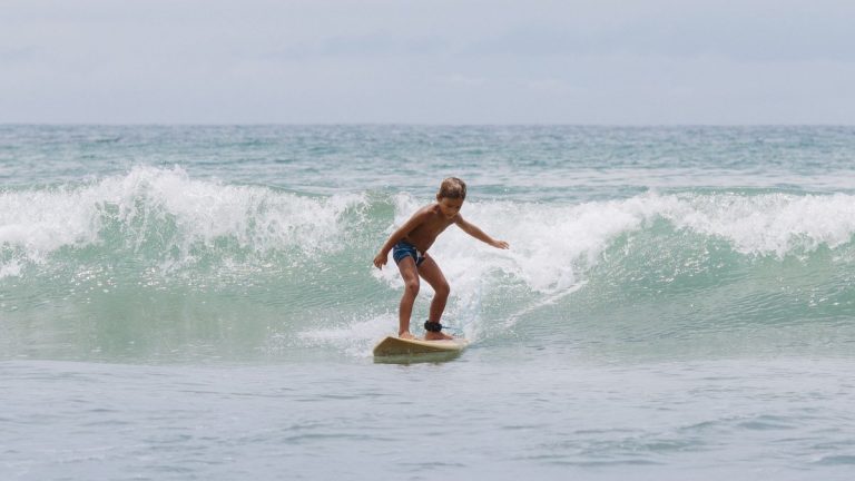 A young surfer riding a gentle ocean wave