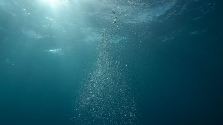 Sunlight penetrating deep blue ocean water