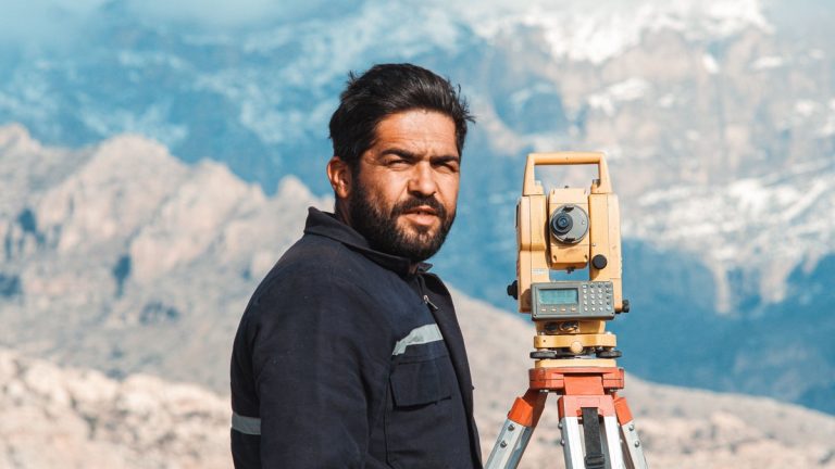 A land surveyor operating geodetic equipment