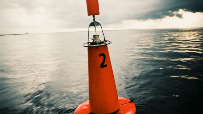 An ocean observation buoy beneath a cloudy sky