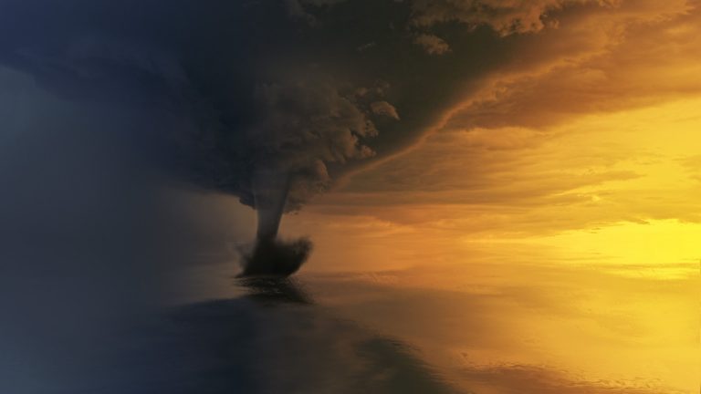 A waterspout extending from a storm cloud to the ocean