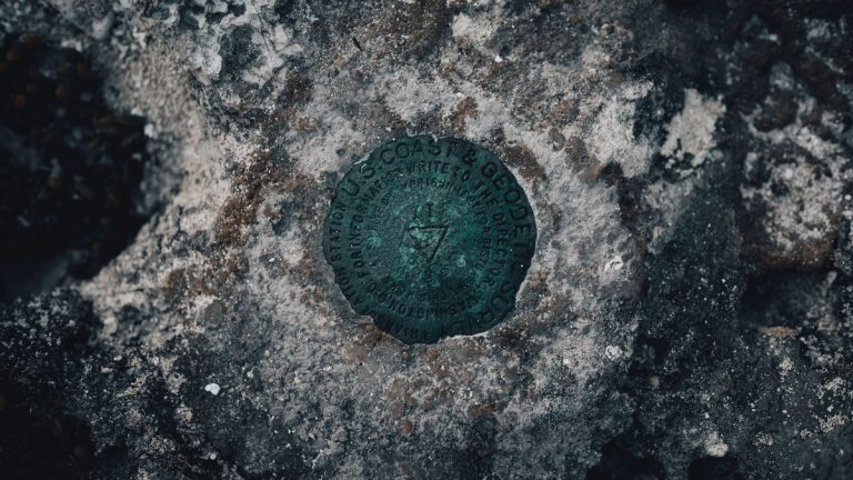 Detailed close-up of a geodetic survey mark embedded in a weathered rock surface