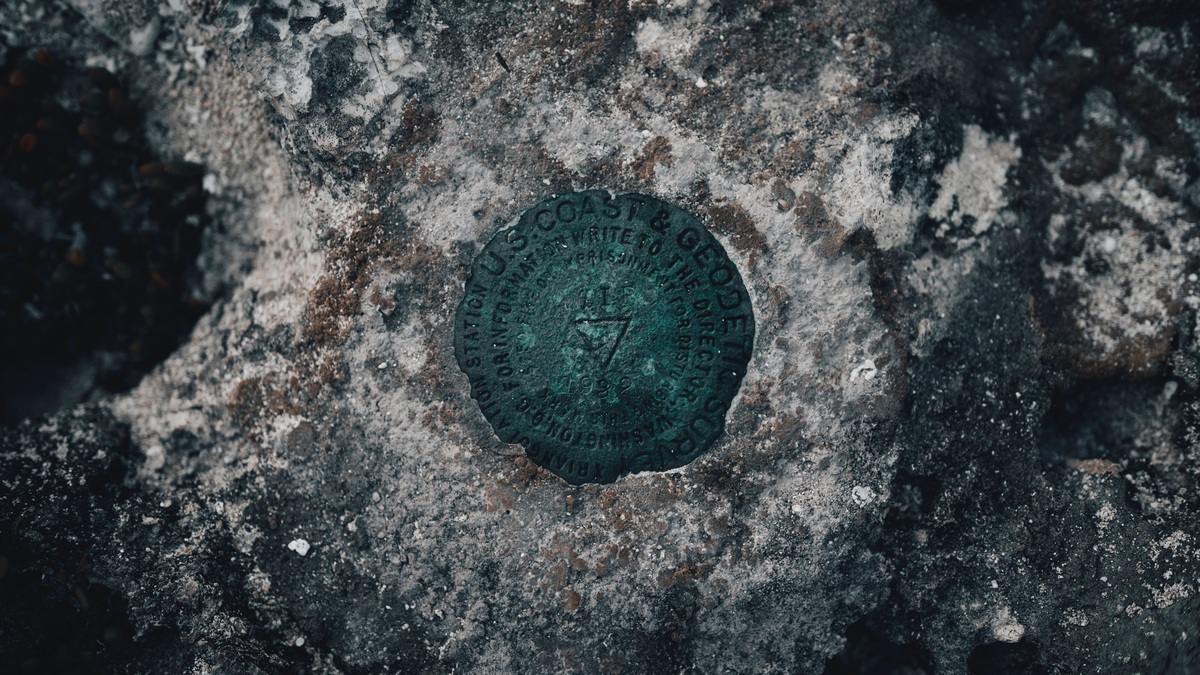 Detailed close-up of a geodetic survey mark embedded in a weathered rock surface