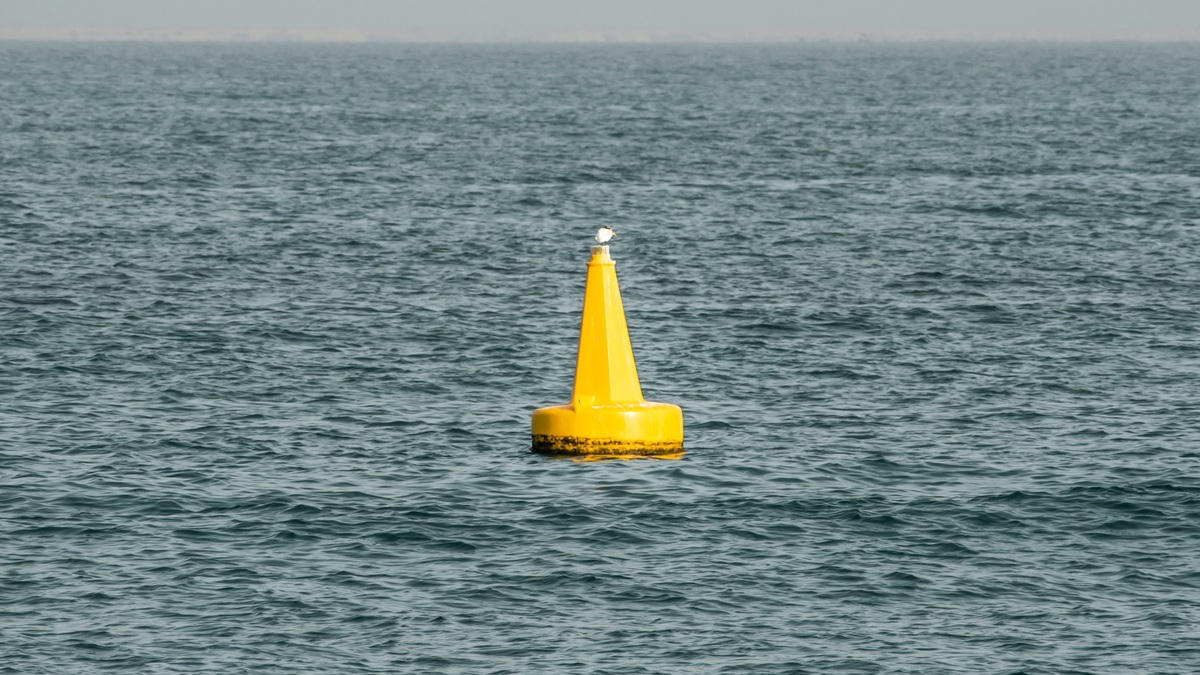 Bright yellow buoy in the ocean, granting safety and direction amid tranquil waters